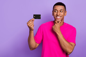 Photo of young minded interested guy handsome touch chin look interested credit card positive...