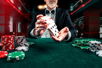 Croupier or casino dealer at gambling club or casino. Close up of male hand. Gambling concept - obrazy, fototapety, plakaty