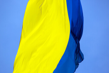 Fototapeta na wymiar waving in the wind the national flag of Ukraine against the blue sky