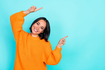 Portrait of optimistic adorable woman with bob hairstyle wear orange sweater indicating empty space...