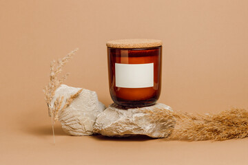 Candle with cork cover in a glass jar with empty label paper mockup, handmade candle on stone...