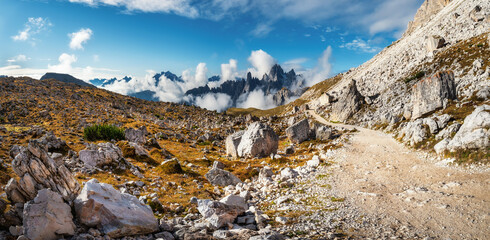 Exciting morning view from the in National Park Tre Cime di Lavaredo hiking trail. Beautiful view with big rocks and mountains.  Dramatic foggy sky. Dolomiti alps, South Tyrol, Italy, Europe
