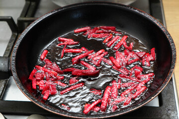 Stewed beets in frying pan. Organic vegetables, healthy vegan eating. Preparation of fried beets.