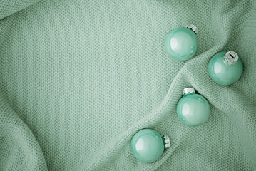 Cute Christmas mint colored balls on a knitted mint fabric.