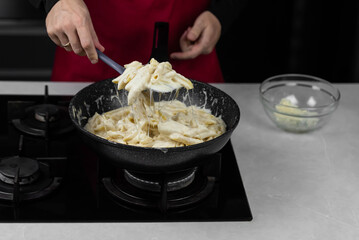 Chef cook making mac and cheese with white cream sauce. Pasta macaroni and liquid yellow cheese. Ingredients: macaroni, milk, cheese, flour, butter.