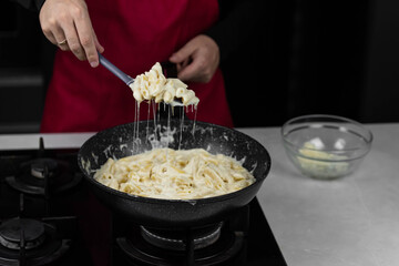 Chef cook making mac and cheese with white cream sauce. Pasta macaroni and liquid yellow cheese. Ingredients: macaroni, milk, cheese, flour, butter.