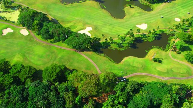 Drone flying over golf course in the morning with sunshine. Golf is a sport and hobby popular with the rich. summer day. green background. 4K