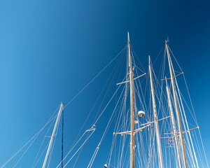 several masts of a yacht without sails