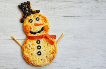 Snowman pizza made it from pizza crust,pizza sauce,black olives,mozzarella cheeses,pepperoni and...
