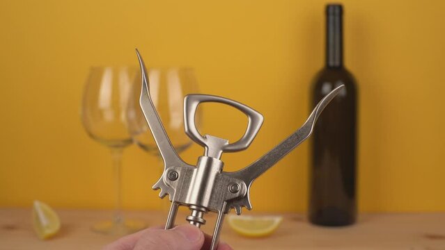a man holds a corkscrew in his hand to open the wine