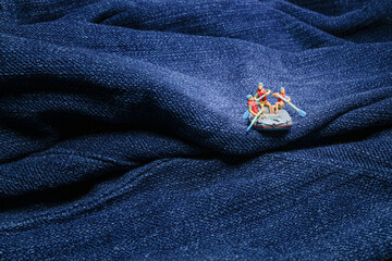 mini People riding down cloth in gorge in raft