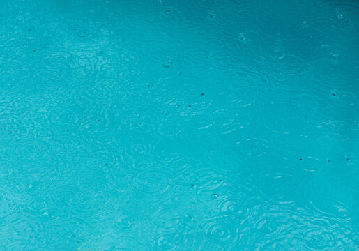 Background Of Swimming Water In A Pool With Rain Drops On The Surface Covered The Ground