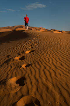 Man walking in a sand desert dunes