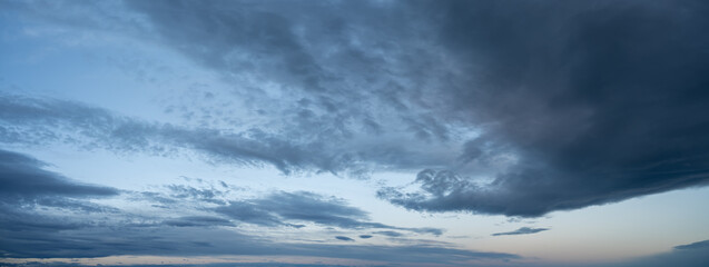 Panorama of evening clouds at blue hour starting just above the horizon
