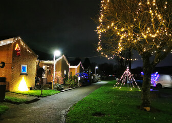Fototapeta premium Outdoor christmas lights and decorations in the gardens on a small Danish street in December