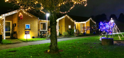 Outdoor christmas lights and decorations in the gardens on a small Danish street in December