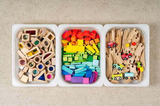 Plastic containers with colorful toy blocks, toy train and wooden railway. Toy Storage boxes in the children's room. Organizing and Storage Ideas in nursery.  Top view