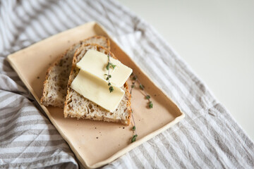 A loaf of bread with butter and sprig of thyme