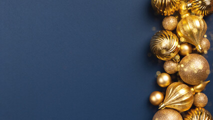 Christmas card with golden glitter balls and toys on blue background with copy space