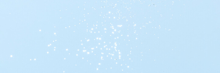 Sparkling silver glitter on blue background banner texture. Abstract holiday blurred lights header. Wide screen wallpaper. Panoramic web banner with copy space for design