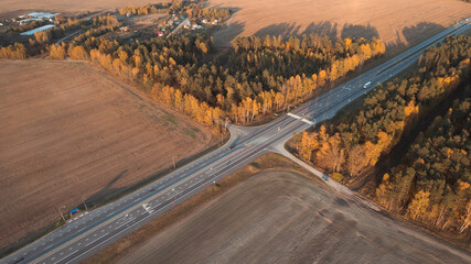 Aerial view of intercity road with fast driving cars at sunset. Top view from drone of highway traffic in evening