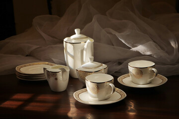 White tea set on a white background. Teapot, cups, plates