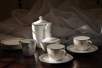 White tea set on a white background. Teapot, cups, plates