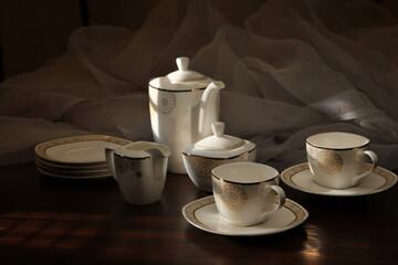 White tea set on a white background. Teapot, cups, plates