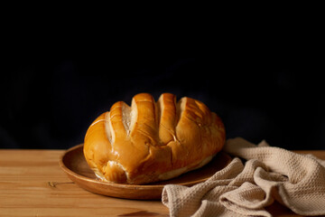 Isolated white bread on wooden table. Dark composition. Bakery concept.