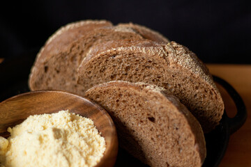 Closeup of brown bread slices on wooden table. Dark composition. Bakery concept.