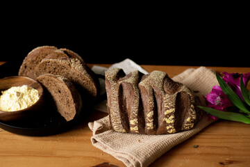 Decorated brown bread on wooden table. Dark composition. Copy Space. Bakery concept.