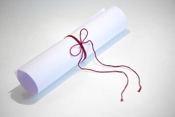White paper roll tied up with red thread, concept image