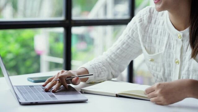 Asian businesswoman working on laptop computer About happy business projects sitting at your desk at home.