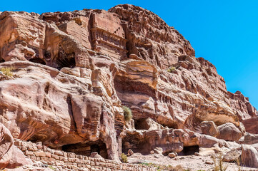 A view of colourful rock formations and cave dwellings beside the Royal Tombs in the ancient city of Petra, Jordan in summertime