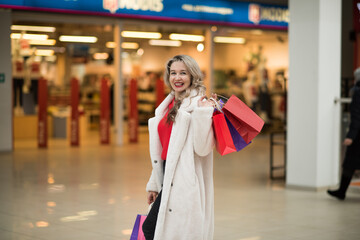 portrait of a young woman with blond hair walking in the mall on black friday sale,black friday...