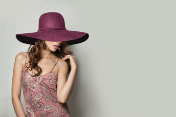 Nice Woman in Pink Silky Dress and pink wide broad brim hat on White Background, Fashion Photo