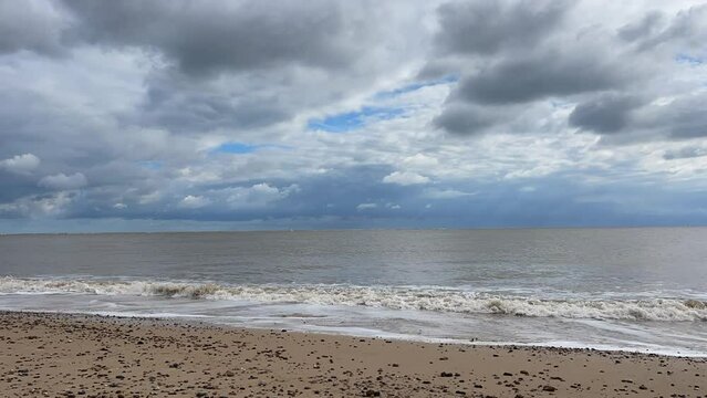 Waves crashing onto the beach with a dramatic cloudy sky background. Timelapse video footage taken in Lowestoft England. 
