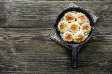 Healthy creamy turkey  meatballs in cast iron skillet on wooden background. Top view, copy space, flat lay.