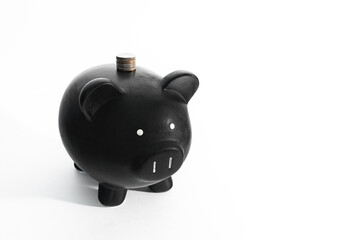 Black piggy bank with pillar of cents on a white background