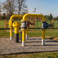 Gas pipes, natural gas transport system. Transmission infrastructure coming from the ground, yellow pipes with valve and flow meter