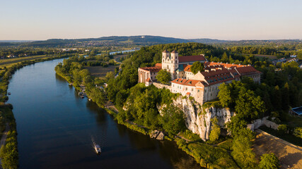 Fototapeta na wymiar Benedictine Abbey in Tyniec is stunning monastery above the river. Historical church on rock with medieval look and mood. Drone footage of this chapel. Landscape of Poland rural countryside sunset.