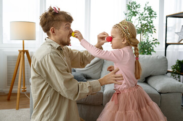 Dad and daughter wearing clown nose having fun