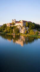 Naklejka na ściany i meble Benedictine Abbey in Tyniec is stunning monastery above the river. Historical church on rock with medieval look and mood. Drone footage of this chapel. Landscape of Poland rural countryside sunset.