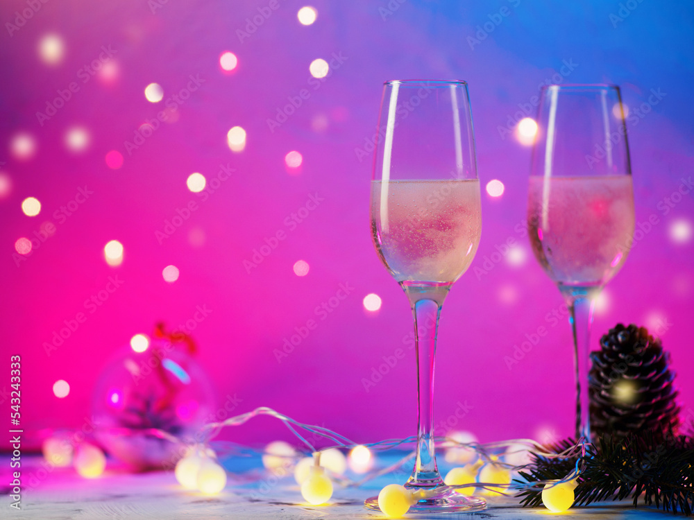 Canvas Prints two glasses of christmas champagne on a purple background with a side garland