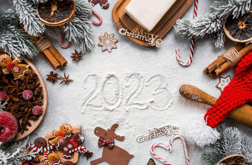 Happy New Year 2023. Banner with kitchen utensils, Christmas decorations, cinnamon, gingerbread and...