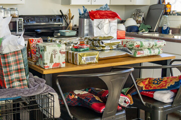 Christmas presents on an island in a cluttered kitchen.