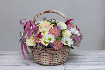 Fototapeta na wymiar Flower arrangement in a box and a basket on the showcase of the flower shop