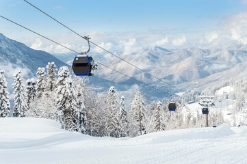 New modern spacious big cabin ski lift gondola against snowcapped forest tree and mountain peaks...