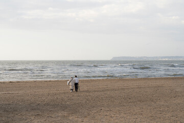 Isolated Old and Young Woman Walks on the Beach of Trouville sur Mer