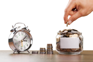 Hand putting Coins in glass jar with alarm clock